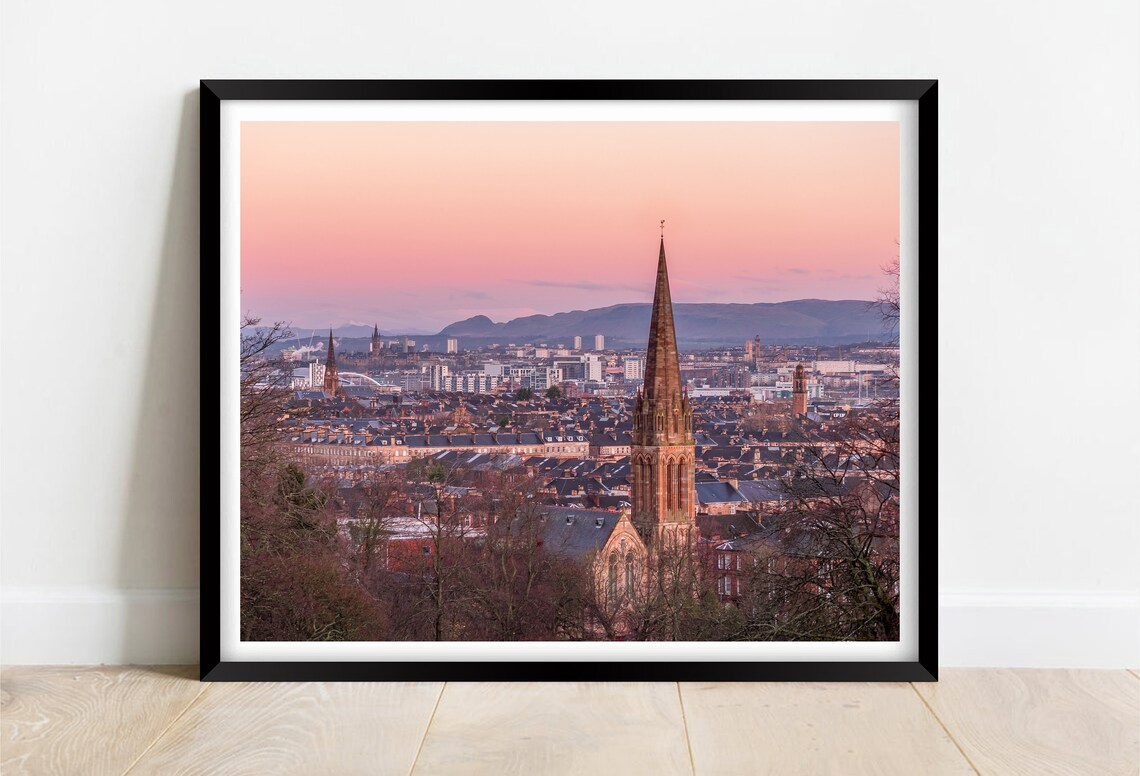 City Skyline at Sunset with a Historic Church Spire in the Foreground Poster
