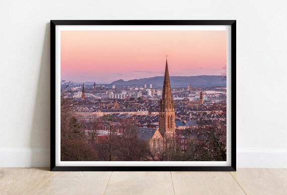 City Skyline at Sunset with a Historic Church Spire in the Foreground Poster