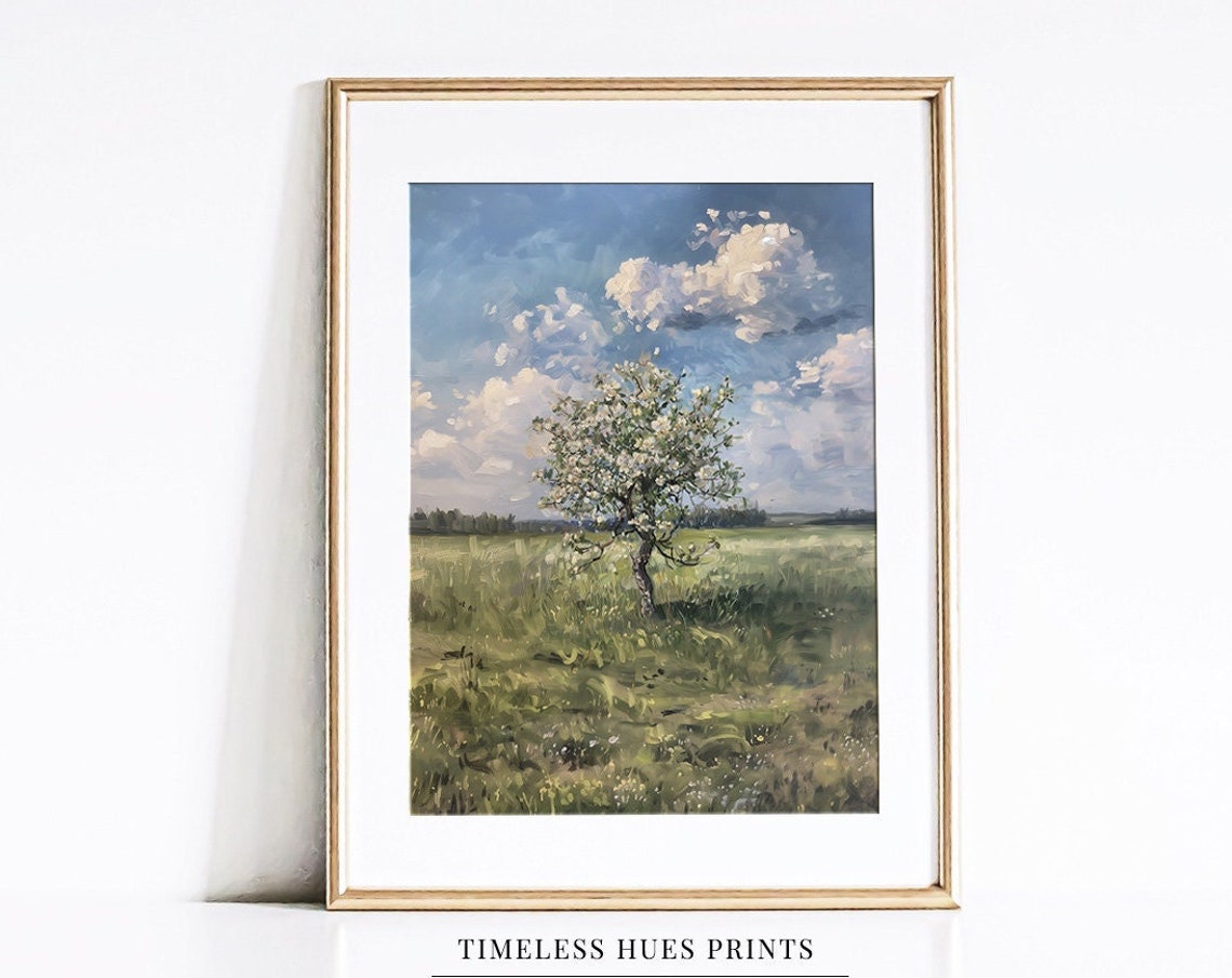 Lone Blossoming Tree Standing In A Green Field Under Clouds Poster