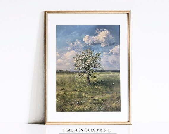 Lone Blossoming Tree Standing In A Green Field Under Clouds Poster