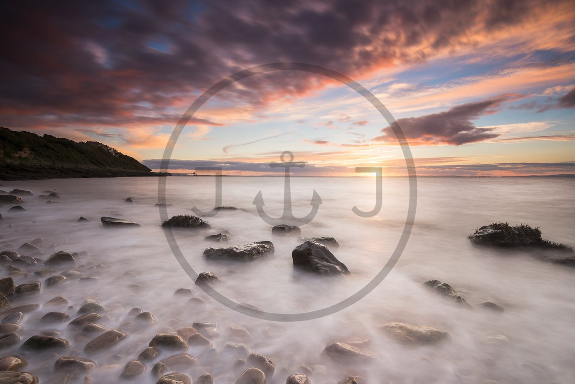 Dramatic Sunset Over Rocky Shoreline with Long Exposure Poster - Image 3