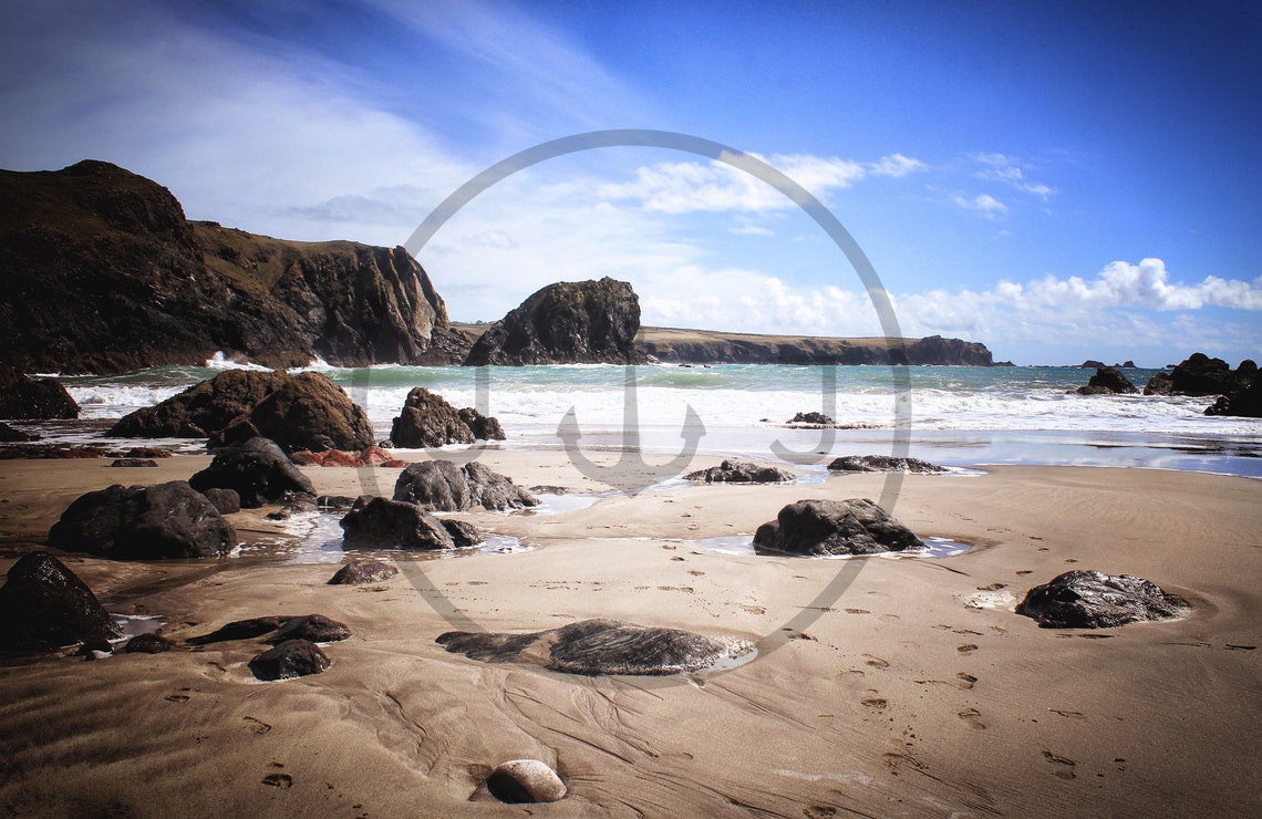 Rocky Beach Cove with a Towering Sea Stack Under a Blue Sky Poster - Image 3