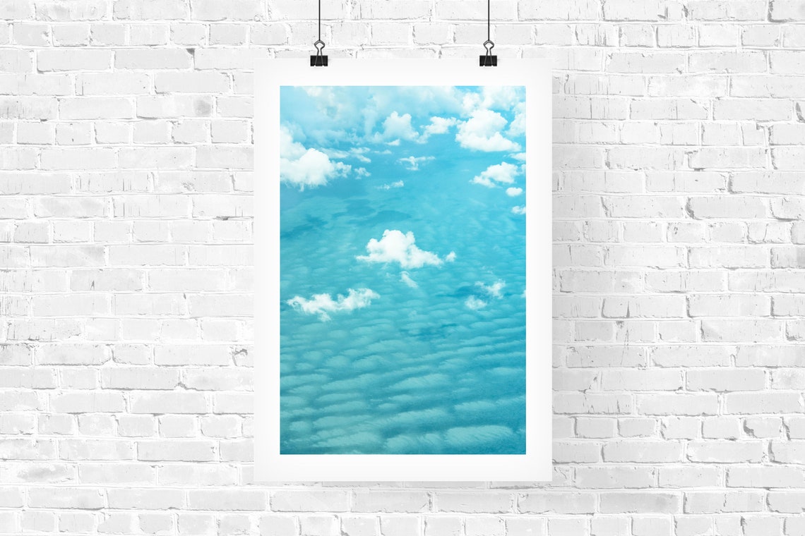 White Clouds Drifting Over a Bright Turquoise Ocean Surface Poster