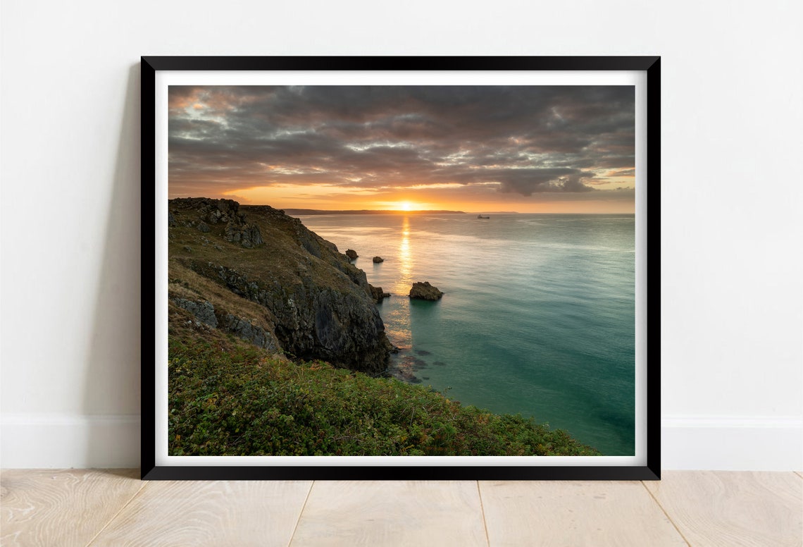 Sunset Over Rocky Coastal Cliffs and Calm Turquoise Sea Poster