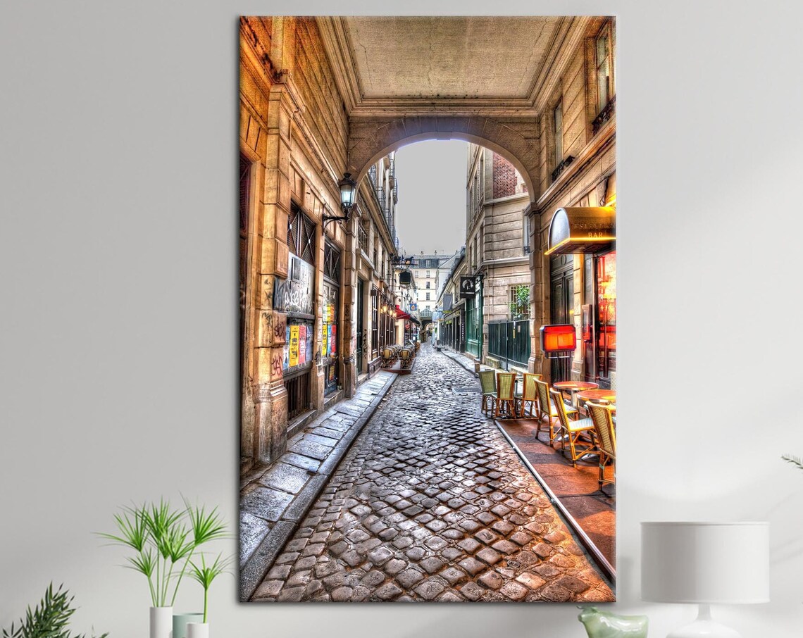 Old Paris Cobblestone Street With Archway and Cafes Canvas Print