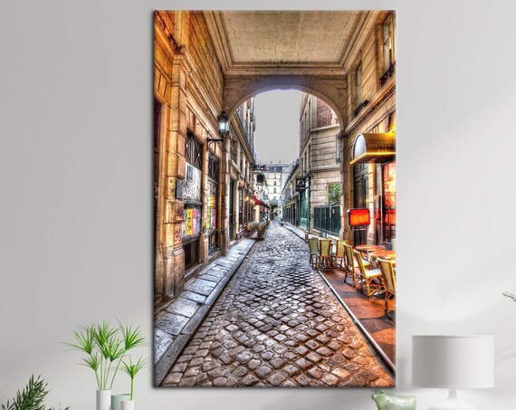 Old Paris Cobblestone Street With Archway and Cafes Canvas Print