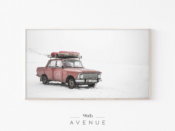 Vintage Red Sedan Carrying Christmas Tree Through Snow Poster