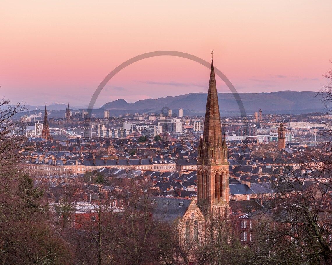 City Skyline at Sunset with a Historic Church Spire in the Foreground Poster - Image 3