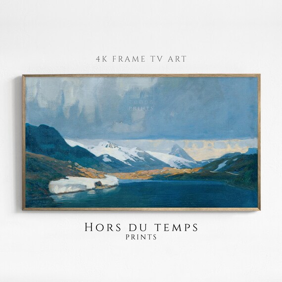 Alpine Lake with Snow Capped Mountains Under Dramatic Winter Sky Poster