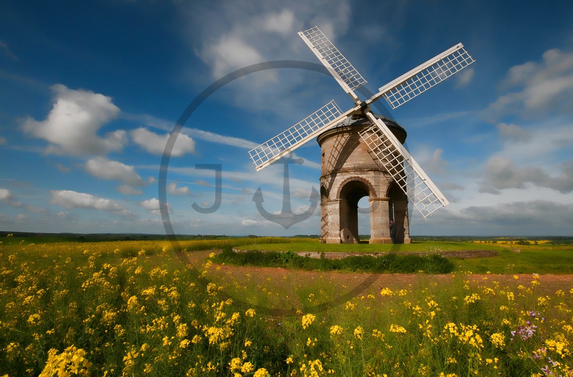Historic Stone Windmill in a Wildflower Meadow Under Blue Sky Poster - Image 3