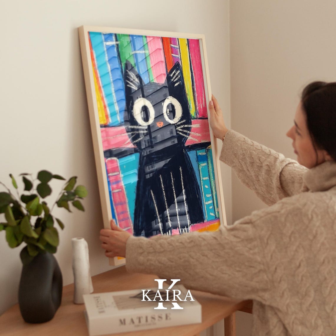 Big-Eyed Black Kitten Sitting by a Colorful Bookshelf Poster - Image 2