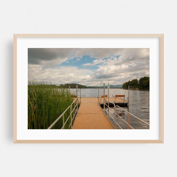 Wooden Boardwalk Over Lake Reeds Under Dramatic Cloudy Sky Poster