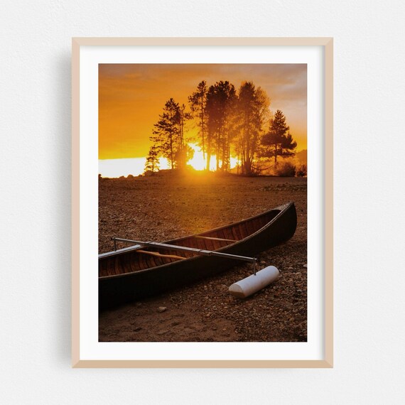 Wooden Canoe On Lakeshore At Sunset Behind Tall Pine Trees Poster