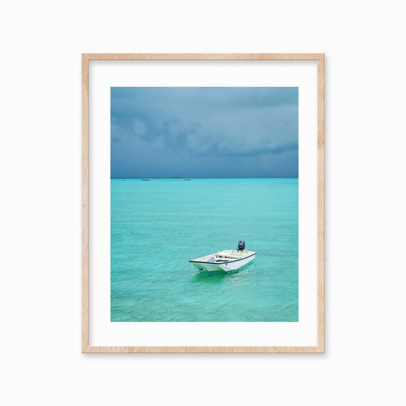 Lone White Motorboat on Vast Turquoise Sea Under Moody Sky Poster