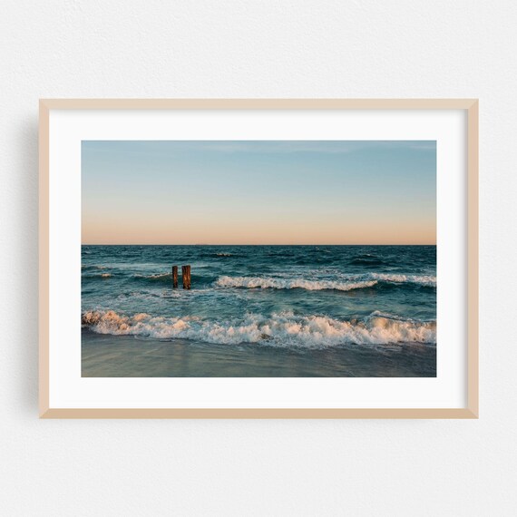 Ocean Sunset With Weathered Wooden Pilings And Rolling Surf Poster
