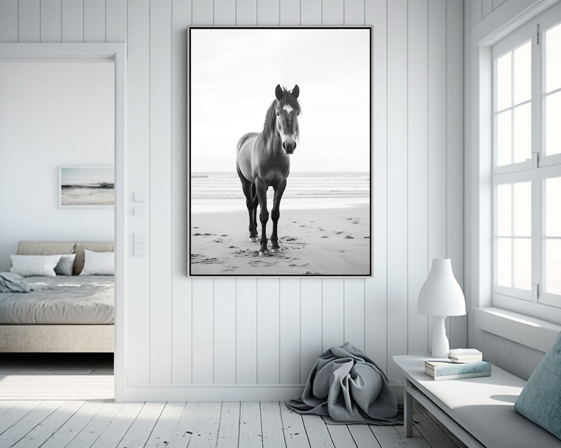 Black and White Photograph of a Horse Standing on the Beach Poster