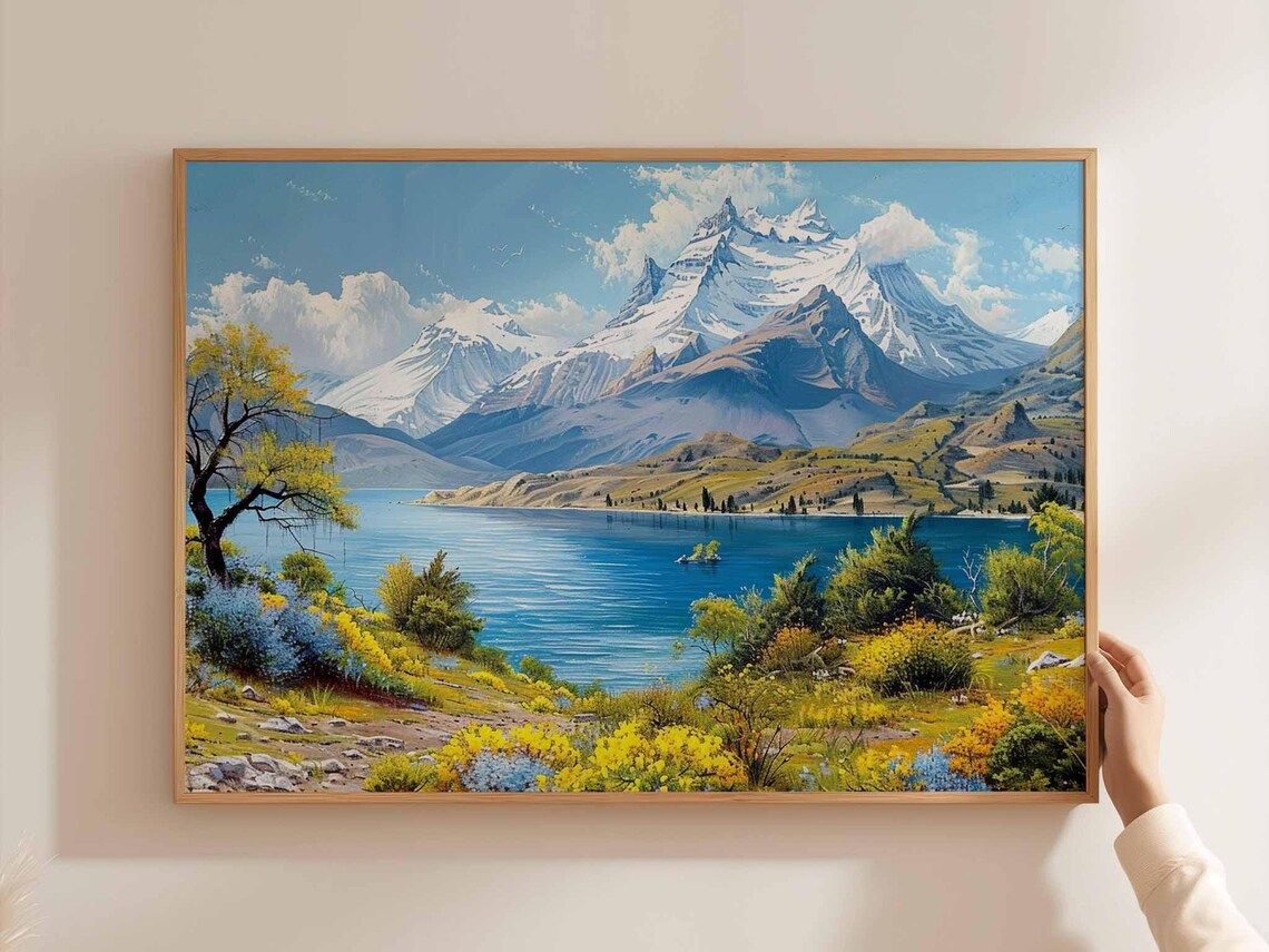 Snowy Peak Over A Blue Lake With Yellow Wildflower Meadow Poster