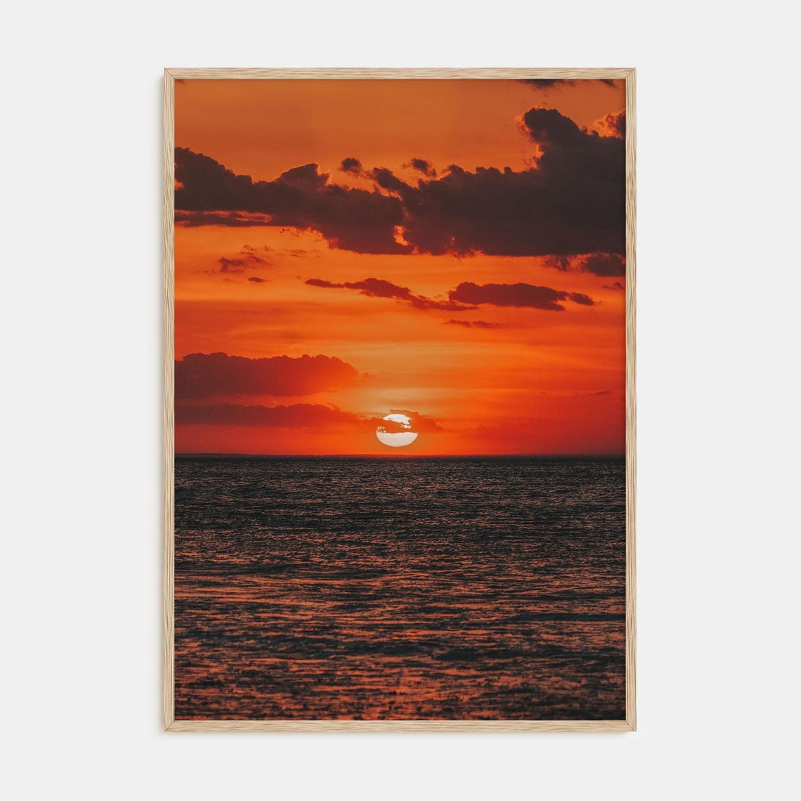 Deep Red Sunset Over the Ocean Horizon With Dark Clouds Poster