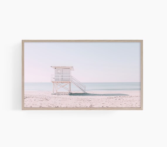White Lifeguard Tower Standing on an Empty Pastel Sandy Beach Poster
