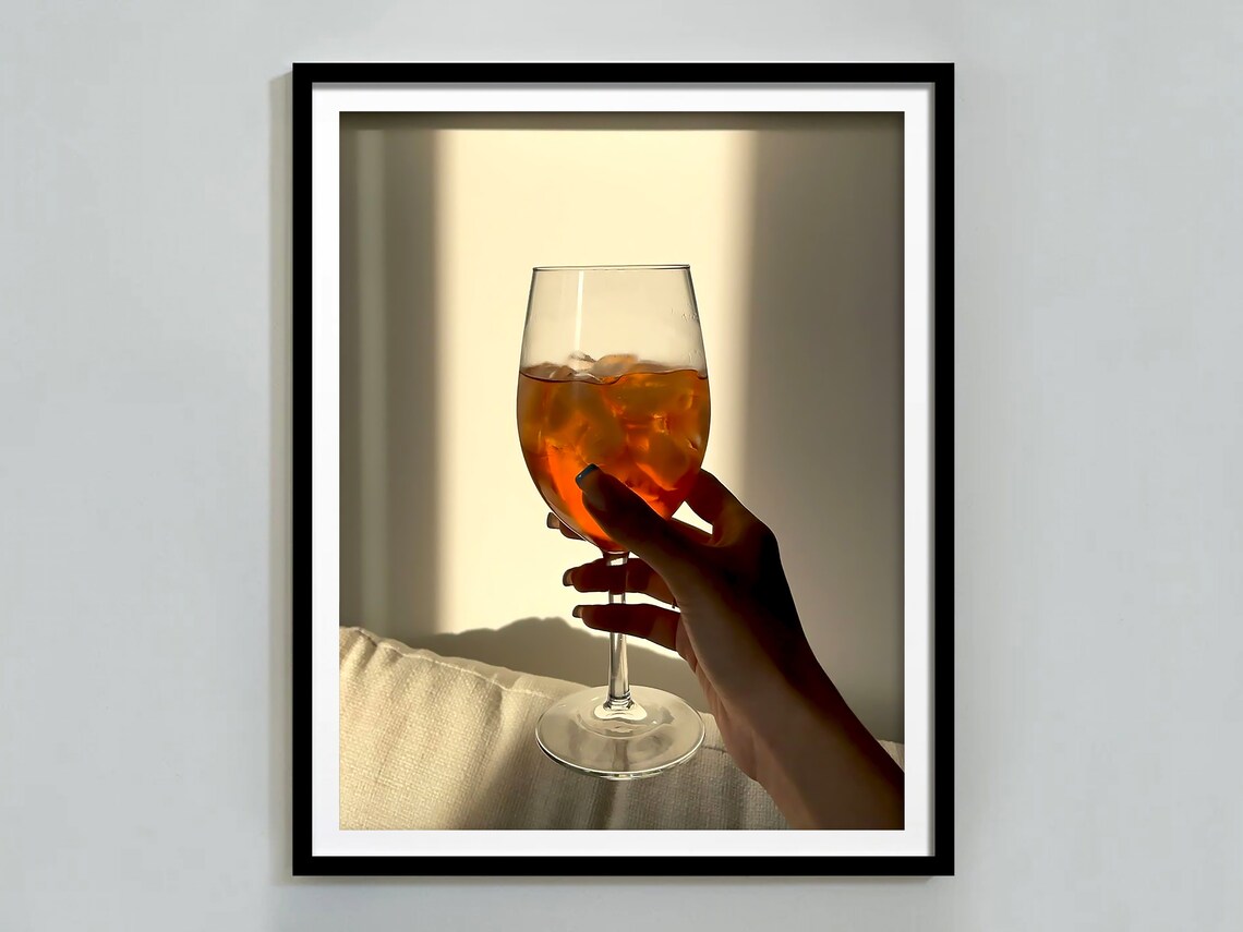 Hand Holding Aperol Spritz Glass in Sunlight Warm Bar Photo Poster