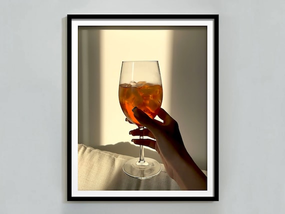 Hand Holding Aperol Spritz Glass in Sunlight Warm Bar Photo Poster