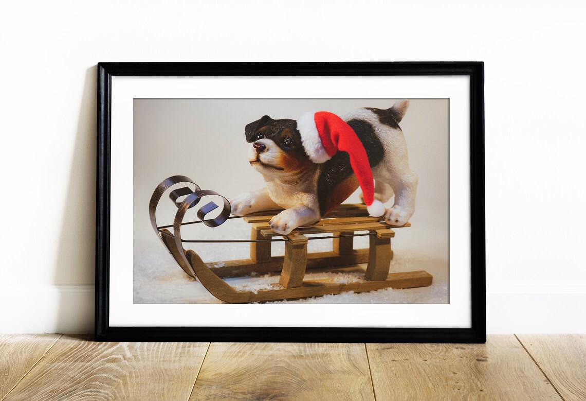 Christmas Puppy In Santa Hat Sitting On Wooden Sleigh In Snow Poster - Image 2