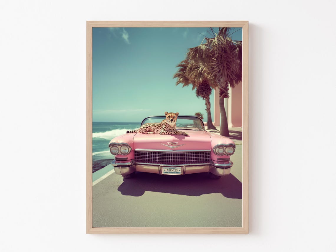 Joyful Cheetah Sprawled on a Pink Classic Car by the Ocean Poster