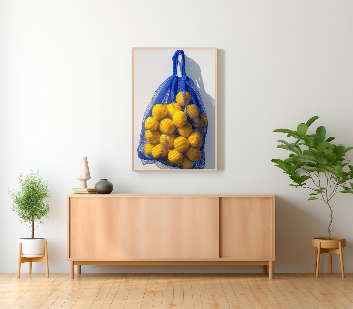 Yellow Lemons in a Blue Net Bag Hanging on a White Wall Photo Print - Image 2