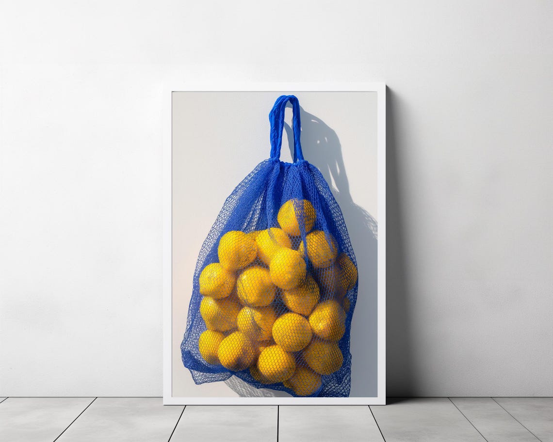 Yellow Lemons in a Blue Net Bag Hanging on a White Wall Photo Print - Image 3