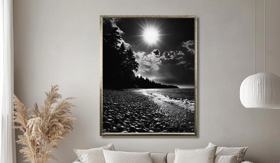 Black And White Pebble Beach With Radiant Sunburst And Waves Poster