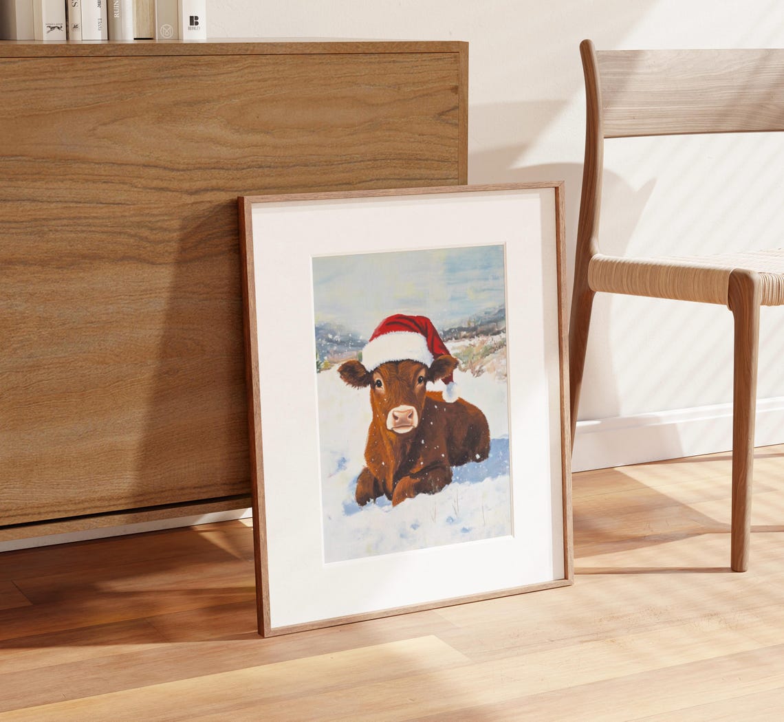 Baby Brown Cow Wearing Santa Hat in a Snowy Field Winter Poster