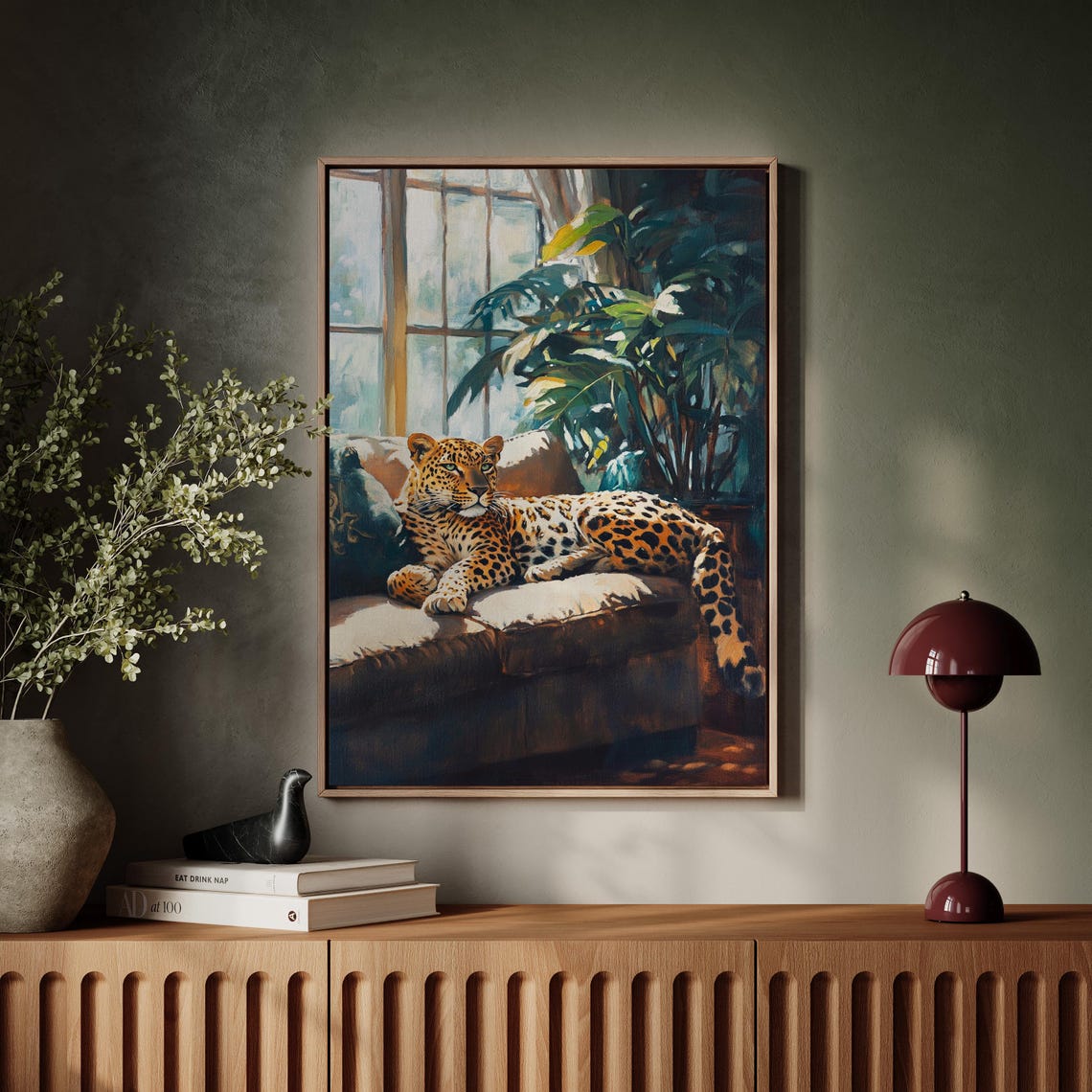 Relaxed Leopard Lounging on a Sunlit Sofa Beside Palm Plants Poster