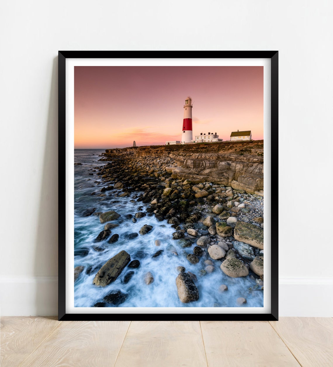 Red and White Striped Lighthouse on a Rocky Coast at Sunset Poster