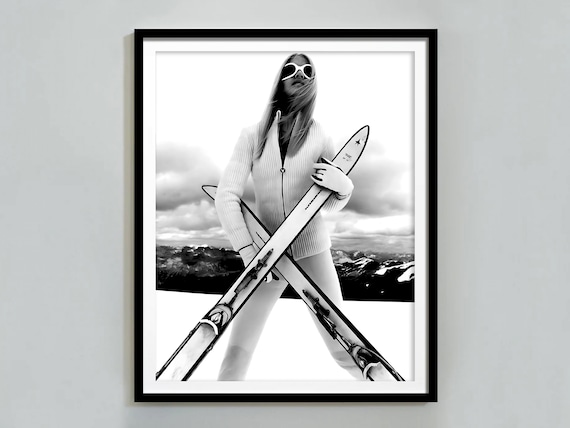 Stylish Woman In White Ski Outfit Holding Crossed Skis Fashion Poster