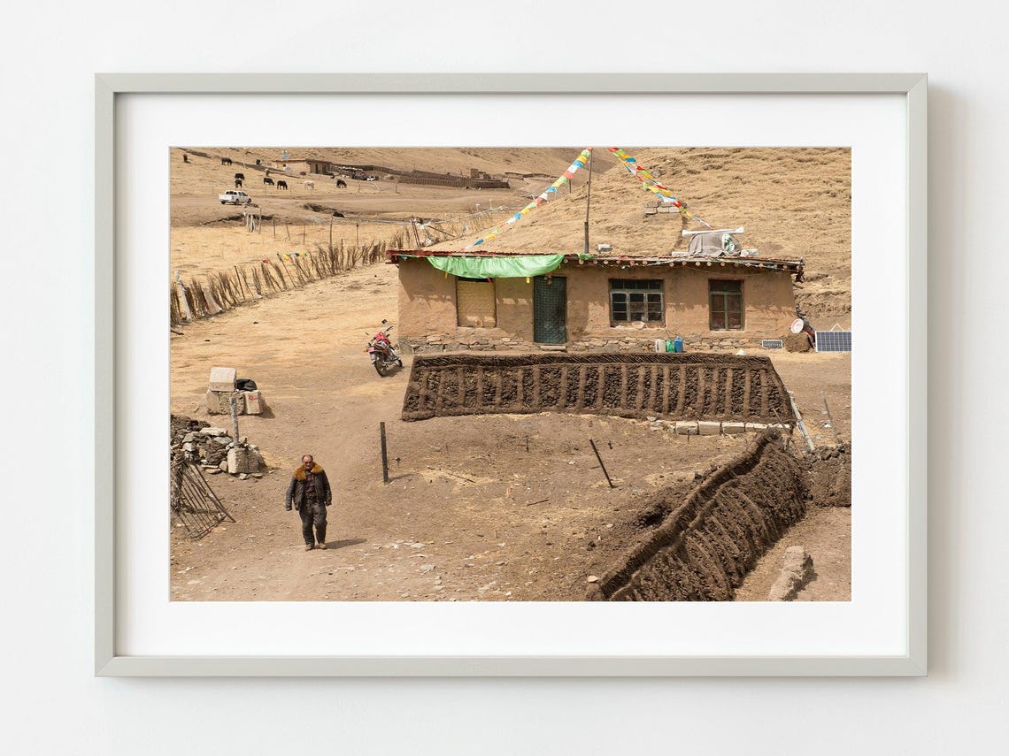Lone Traveler Walking To Earthen House With Prayer Flags Photo Poster
