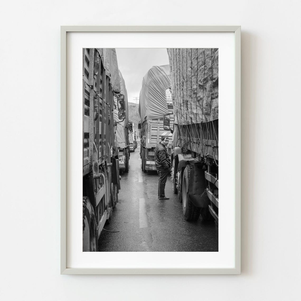 Man Between Parked Trucks On Blocked Road Black And White Poster