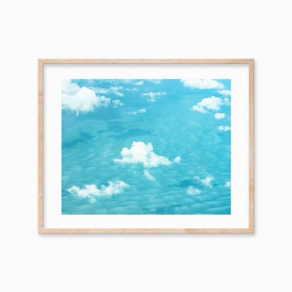 Puffy White Clouds Floating Over a Turquoise Blue Sea Poster