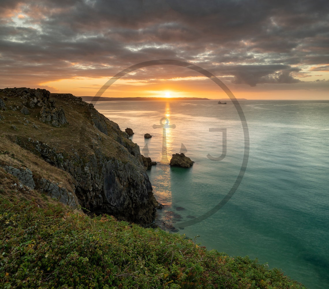 Sunset Over Rocky Coastal Cliffs and Calm Turquoise Sea Poster - Image 3