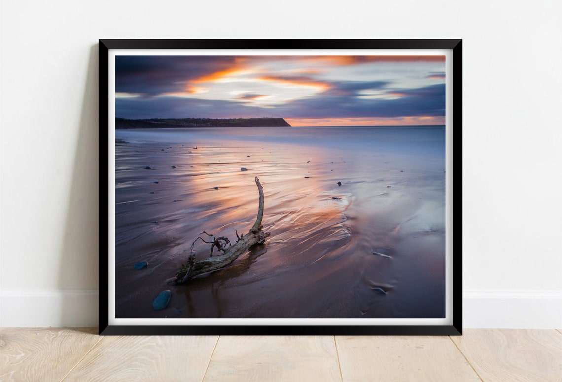 Driftwood Resting on Wet Sand Under a Soft Pink Twilight Sky Poster