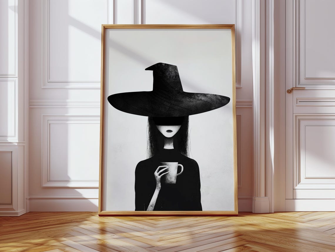 Moody Witch in Oversized Black Hat Cradling a Coffee Cup Poster