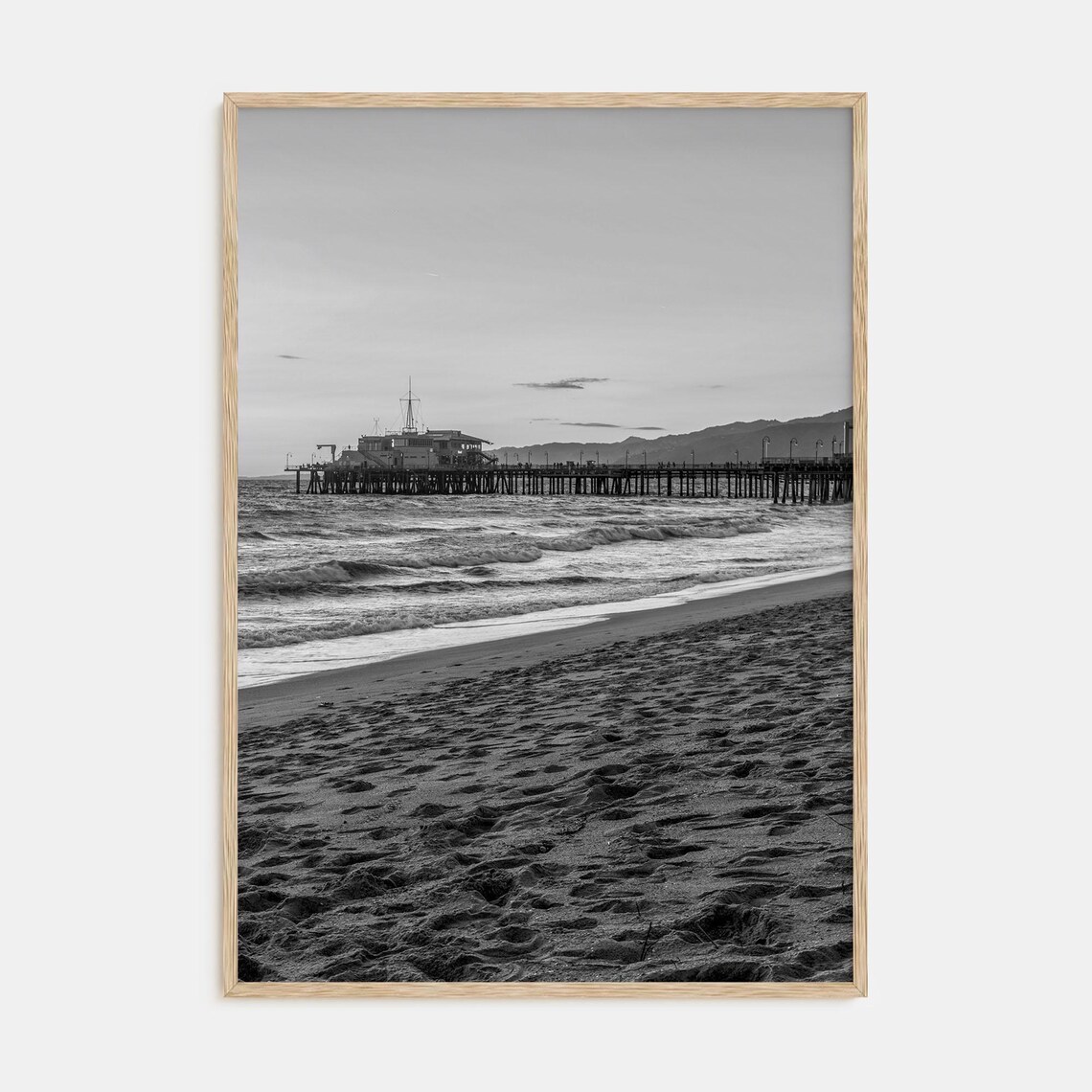 Black and White Photograph of a Pier Stretching Over the Ocean Poster