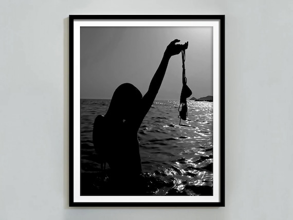 Woman Silhouette Holding Swimsuit in Ocean at Sunset Photo Poster