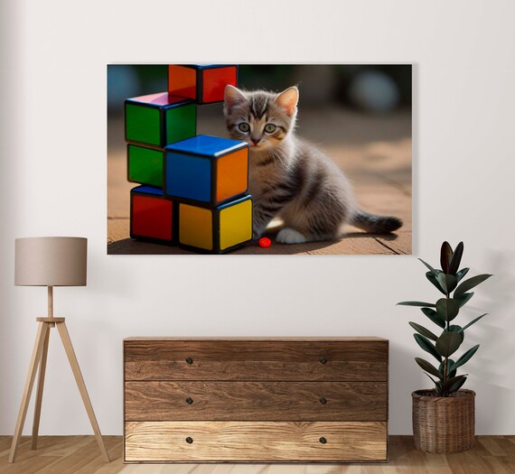 Tabby Kitten Peeking Beside Tall Stack Of Rubiks Cubes Poster