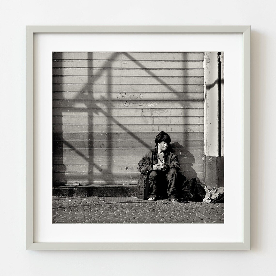 Person Sitting By Closed Shutter Black And White Street Photo Poster