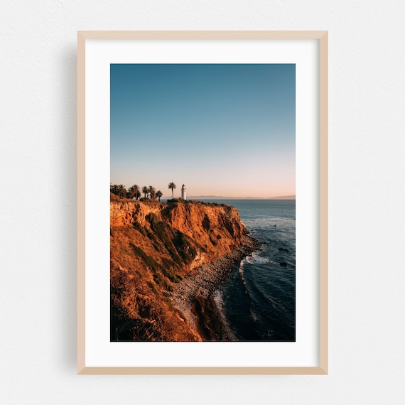 Coastal Lighthouse at Sunset Over Palm-Topped Cliffs Photography Poster