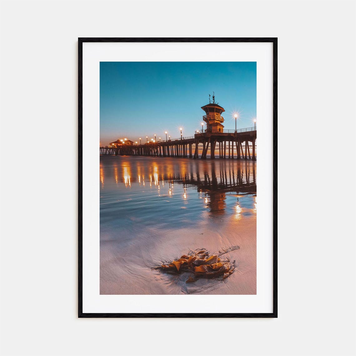 Ocean Pier Glowing at Blue Hour with Lights Reflected on Water Print