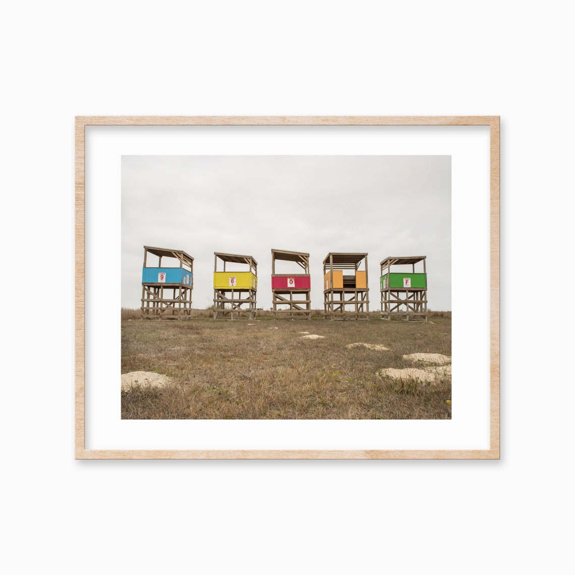 Row of Five Colorful Lifeguard Stands on Sandy Beach Photo Poster