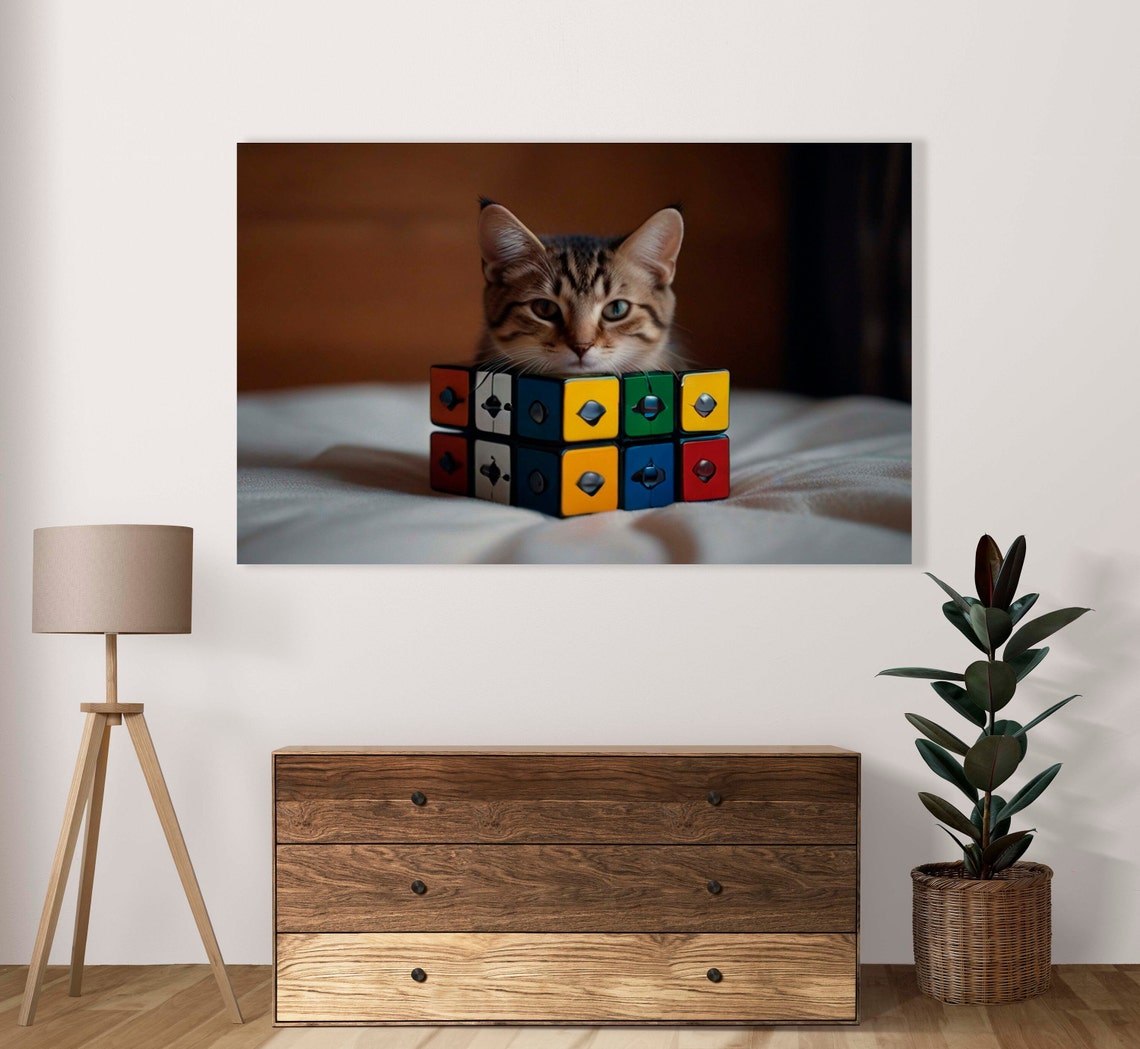 Tabby Cat Peeking Over A Colorful Rubiks Cube On A Bed Poster