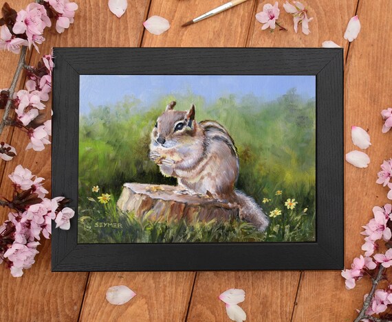 Cute Striped Chipmunk Sitting on a Tree Stump in a Sunny Meadow Poster