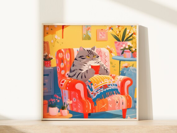 Relaxed Grey Tabby Cat Holding Red Mug in Patterned Armchair Poster